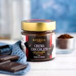 RIVELIA Chocolate Spread 240 g är en lyxig italiensk chokladkräm med djup chokladsmak och hasselnöt. Krämig, hantverksmässigt tillverkad och perfekt till dessert, kaffe och frukost.